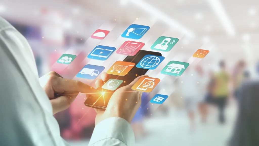 Photo of a person holding a smartphone surrounded by floating icons representing marketing, retail, delivery, payments, and communication channels, illustrating unified customer data activation.